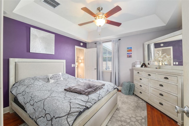 7547 SW 87th Ter, Gainesville, FL 32608 - bedroom with a tray ceiling, wood finished floors, and a ceiling fan