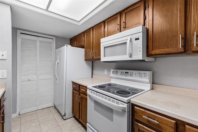 7074 NW 52nd Ter, Gainesville, FL 32653 - kitchen with white appliances, brown cabinets, light countertops, and light tile patterned flooring