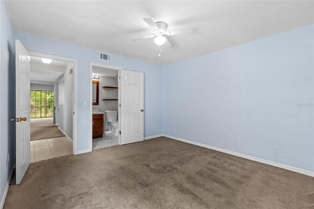 7074 NW 52nd Ter, Gainesville, FL 32653 - unfurnished bedroom with carpet, tile patterned flooring, ensuite bath, and a ceiling fan