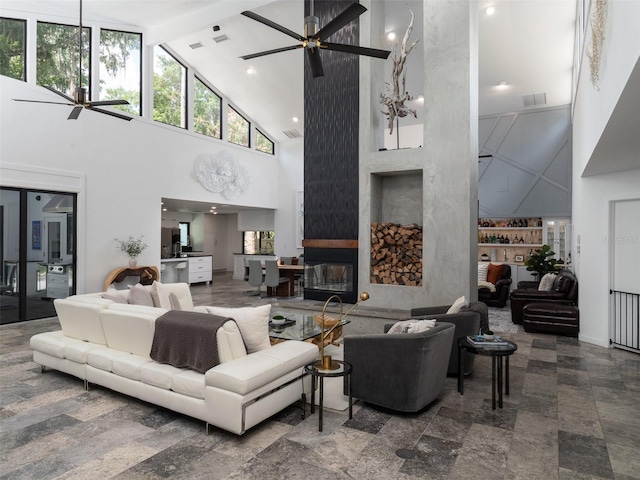 2261 NW 24th Ave, Gainesville, FL 32605 - living room featuring ceiling fan, high vaulted ceiling, a fireplace, beam ceiling, and built in shelves