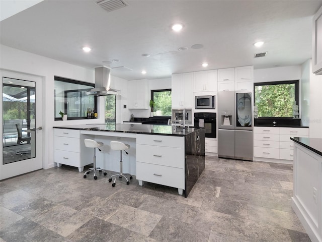 2261 NW 24th Ave, Gainesville, FL 32605 - kitchen with stainless steel appliances, island exhaust hood, dark countertops, white cabinetry, and recessed lighting