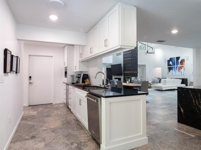 2261 NW 24th Ave, Gainesville, FL 32605 - kitchen with dishwasher, dark countertops, white cabinets, a ceiling fan, and open floor plan
