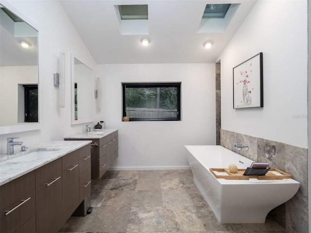 2261 NW 24th Ave, Gainesville, FL 32605 - full bath featuring a soaking tub, two vanities, lofted ceiling, and stone finish flooring