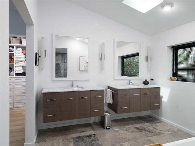 2261 NW 24th Ave, Gainesville, FL 32605 - full bathroom with two vanities, lofted ceiling, a spacious closet, and a skylight