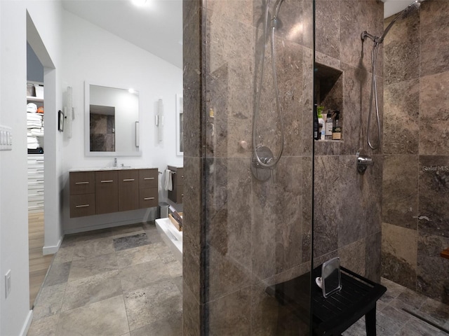 2261 NW 24th Ave, Gainesville, FL 32605 - full bathroom with a stall shower, vanity, vaulted ceiling, and stone finish flooring