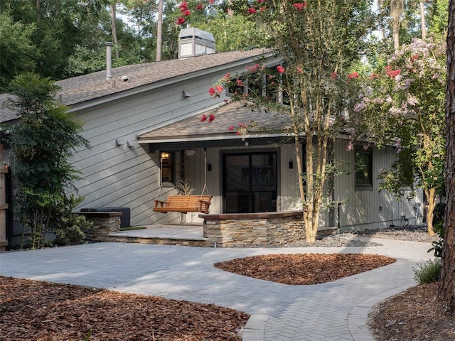 2261 NW 24th Ave, Gainesville, FL 32605 - view of front facade featuring covered porch, a shingled roof, and a chimney