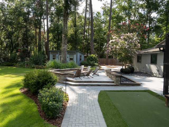 2261 NW 24th Ave, Gainesville, FL 32605 - view of yard with an area to practice putting, a patio, and an outbuilding