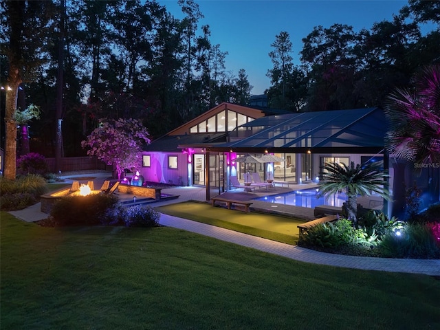 2261 NW 24th Ave, Gainesville, FL 32605 - back of house at twilight with a fire pit, a lawn, an outdoor pool, and a patio area