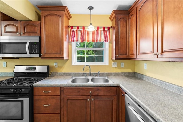 3404 NW 4th St, Gainesville, FL 32609 - kitchen with appliances with stainless steel finishes, decorative light fixtures, light countertops, and brown cabinets