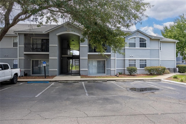 3705 SW 27th St Unit 525, Gainesville, FL 32608 - view of property featuring uncovered parking and stairs