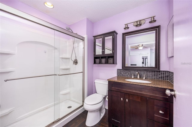 3705 SW 27th St Unit 525, Gainesville, FL 32608 - full bath featuring a stall shower, decorative backsplash, vanity, a textured ceiling, and wood finished floors