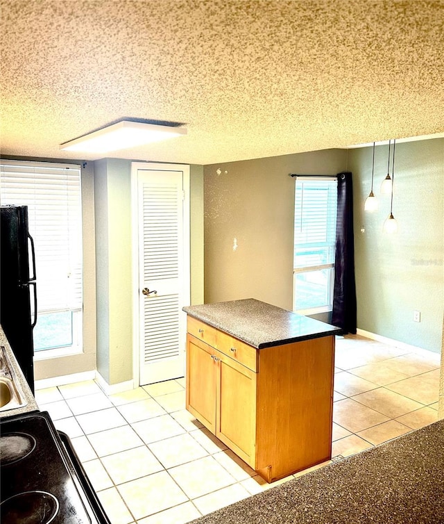 1810 NW 23rd Blvd Unit 272, Gainesville, FL 32605 - kitchen featuring freestanding refrigerator, light tile patterned flooring, plenty of natural light, and a textured ceiling