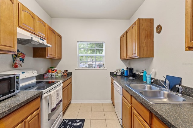 1573 NW 29th Rd Unit 3, Gainesville, FL 32605 - kitchen featuring white appliances, under cabinet range hood, dark countertops, light tile patterned floors, and brown cabinets