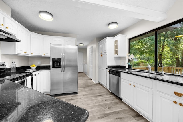 2101 SW 79th Dr, Gainesville, FL 32607 - kitchen featuring stainless steel appliances, under cabinet range hood, white cabinets, dark stone counters, and light wood-style flooring
