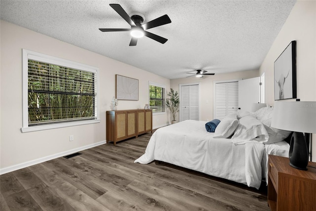 2101 SW 79th Dr, Gainesville, FL 32607 - bedroom featuring a textured ceiling, two closets, wood finished floors, and ceiling fan