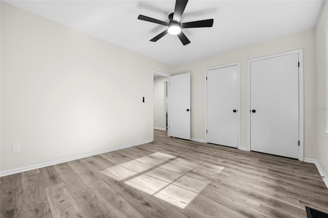 2101 SW 79th Dr, Gainesville, FL 32607 - unfurnished bedroom featuring wood finished floors, a ceiling fan, and multiple closets