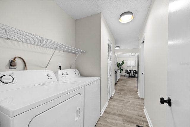 2101 SW 79th Dr, Gainesville, FL 32607 - washroom featuring separate washer and dryer and light wood finished floors