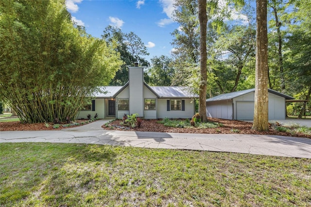 2101 SW 79th Dr, Gainesville, FL 32607 - mid-century modern home featuring a chimney, a metal roof, a front lawn, an outdoor structure, and concrete driveway
