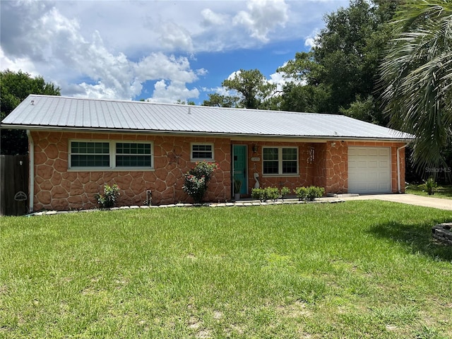 1255 NE 2nd St, Crystal River, FL 34429 - ranch-style house with an attached garage, a metal roof, driveway, a front lawn, and stone siding