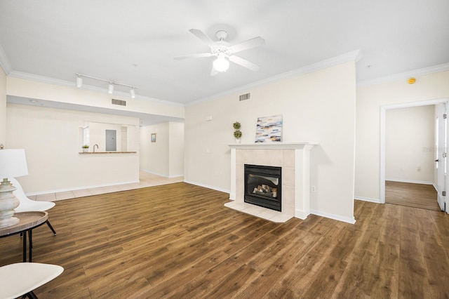 5133 SW 91st Ct Unit G202, Gainesville, FL 32608 - unfurnished living room featuring wood finished floors, ornamental molding, ceiling fan, and a tile fireplace