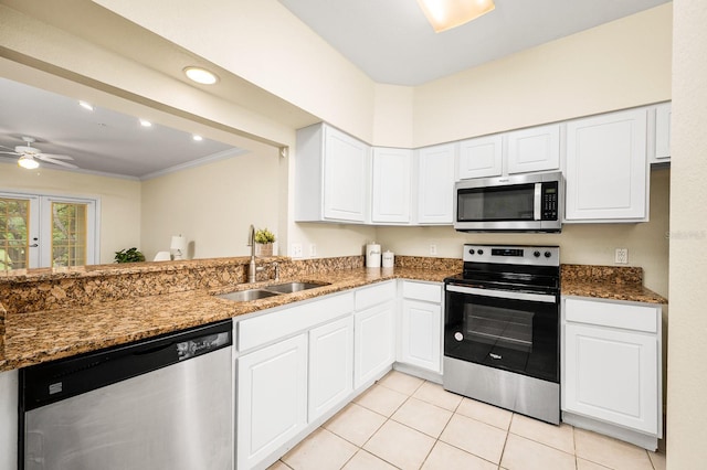 5133 SW 91st Ct Unit G202, Gainesville, FL 32608 - kitchen featuring appliances with stainless steel finishes, dark stone countertops, white cabinets, light tile patterned floors, and crown molding