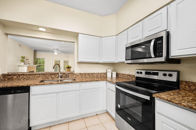 5133 SW 91st Ct Unit G202, Gainesville, FL 32608 - kitchen featuring appliances with stainless steel finishes, white cabinetry, a ceiling fan, and dark stone countertops