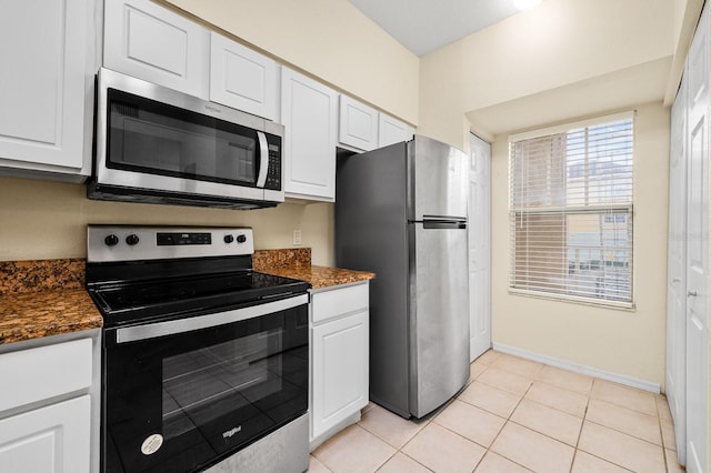5133 SW 91st Ct Unit G202, Gainesville, FL 32608 - kitchen with stainless steel appliances, dark countertops, white cabinets, and light tile patterned flooring