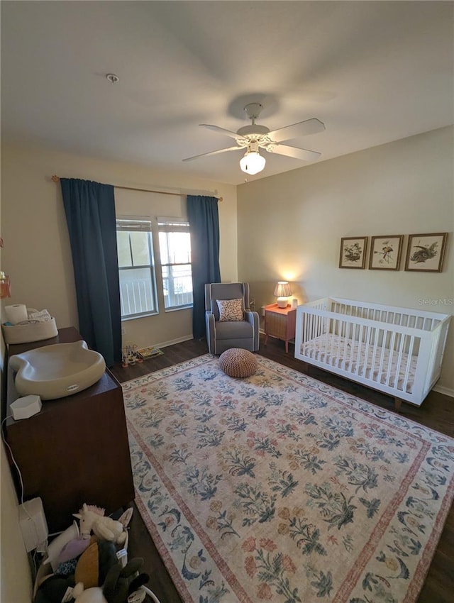 5133 SW 91st Ct Unit G202, Gainesville, FL 32608 - bedroom with wood finished floors, a nursery area, and a ceiling fan
