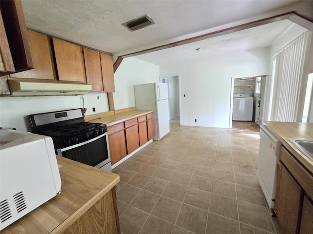 18248 High Springs Main St, High Springs, FL 32643 - kitchen with white appliances, washer / clothes dryer, under cabinet range hood, and light countertops