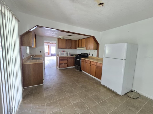 18248 High Springs Main St, High Springs, FL 32643 - kitchen featuring white appliances, brown cabinetry, light countertops, and under cabinet range hood
