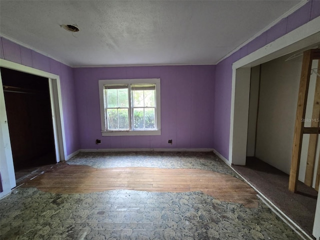 18248 High Springs Main St, High Springs, FL 32643 - unfurnished bedroom with crown molding, wood finished floors, a textured ceiling, and a closet