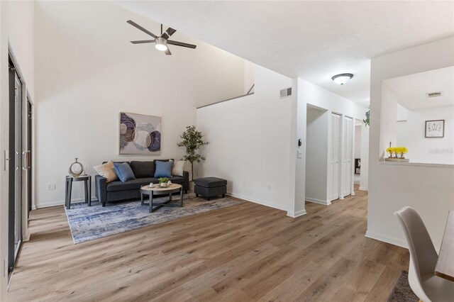 303 SW 54th Dr, Gainesville, FL 32607 - living area featuring ceiling fan, light wood-style flooring, and a towering ceiling