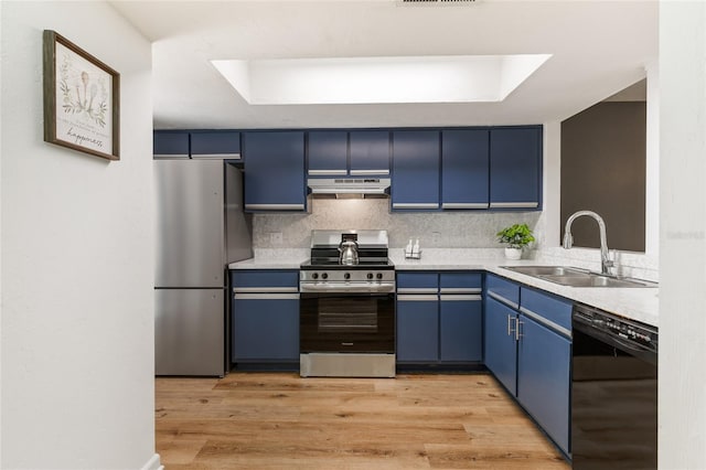303 SW 54th Dr, Gainesville, FL 32607 - kitchen with appliances with stainless steel finishes, blue cabinetry, under cabinet range hood, decorative backsplash, and light countertops