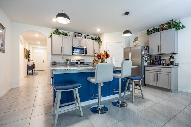 216 Hickory Crse, Ocala, FL 34472 - kitchen with appliances with stainless steel finishes, arched walkways, light tile patterned flooring, a kitchen breakfast bar, and recessed lighting