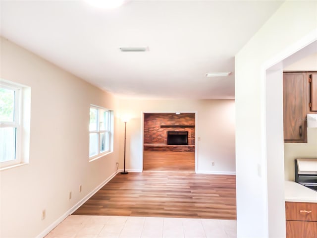 1601 NE 28th Ave, Gainesville, FL 32609 - unfurnished living room featuring light wood finished floors and a fireplace