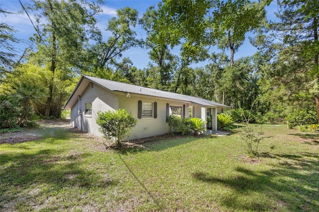 4923 SW Ichetucknee Ave, Fort White, FL 32038 - view of home's exterior with a yard, stucco siding, and a metal roof