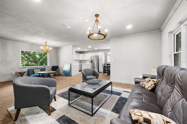 4923 SW Ichetucknee Ave, Fort White, FL 32038 - living area with a chandelier, light wood-style floors, ornamental molding, a textured ceiling, and recessed lighting