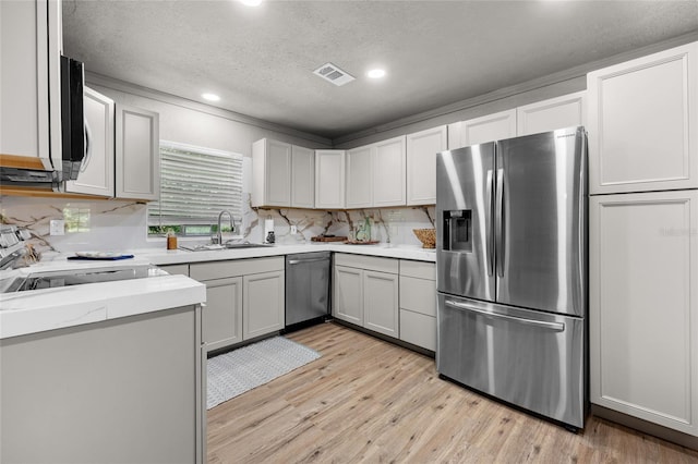 4923 SW Ichetucknee Ave, Fort White, FL 32038 - kitchen with appliances with stainless steel finishes, light wood-style floors, a textured ceiling, recessed lighting, and backsplash