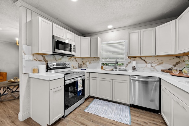 4923 SW Ichetucknee Ave, Fort White, FL 32038 - kitchen with stainless steel appliances, a textured ceiling, light wood-type flooring, light countertops, and backsplash