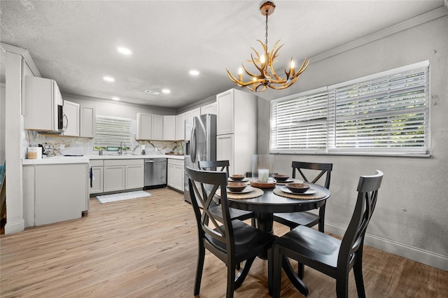 4923 SW Ichetucknee Ave, Fort White, FL 32038 - dining space featuring a chandelier, light wood-style flooring, recessed lighting, a textured wall, and crown molding