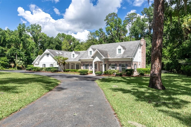 2506 SW 9th Dr, Gainesville, FL 32601 - cape cod-style house featuring a chimney, brick siding, and a front yard