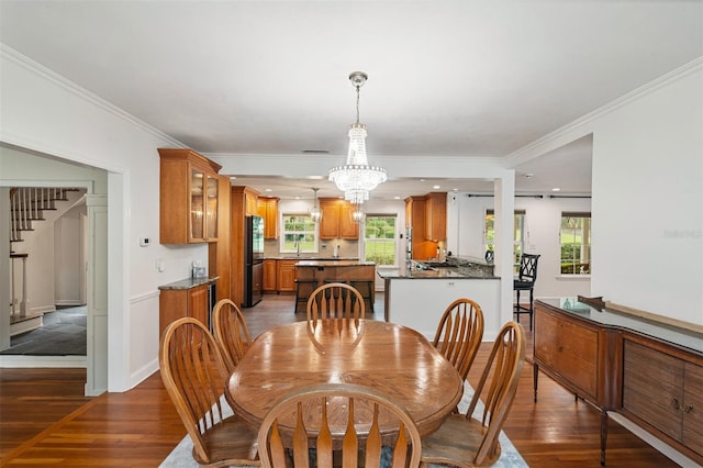 2506 SW 9th Dr, Gainesville, FL 32601 - dining space featuring wood finished floors, a chandelier, ornamental molding, and stairway