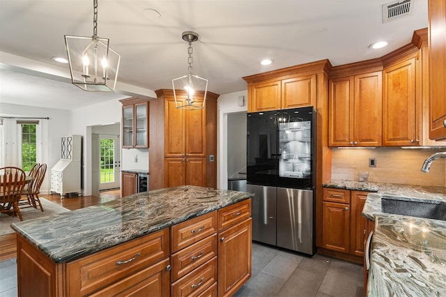 2506 SW 9th Dr, Gainesville, FL 32601 - kitchen featuring smart refrigerator, brown cabinets, recessed lighting, a center island, and dark stone counters