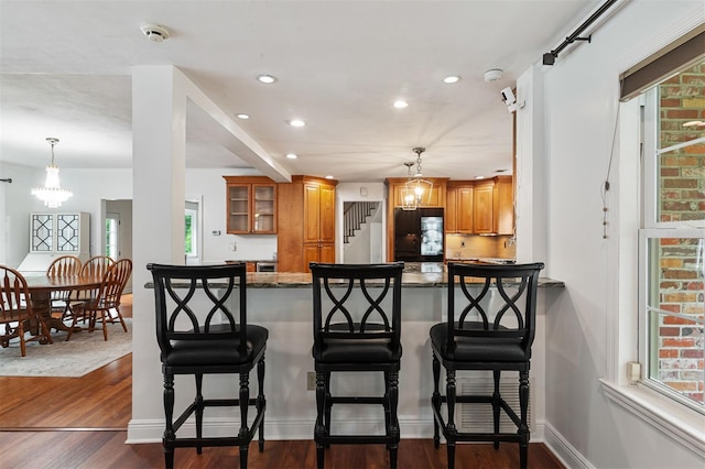 2506 SW 9th Dr, Gainesville, FL 32601 - kitchen with brown cabinetry, dark wood finished floors, a peninsula, recessed lighting, and glass insert cabinets