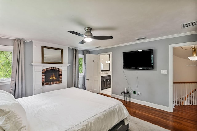 2506 SW 9th Dr, Gainesville, FL 32601 - bedroom featuring wood finished floors, crown molding, a fireplace, a ceiling fan, and ensuite bath