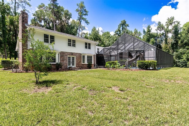 2506 SW 9th Dr, Gainesville, FL 32601 - rear view of house with a chimney, brick siding, a lawn, and french doors