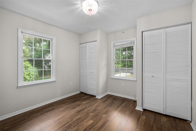 5328 SW 88th Ct, Gainesville, FL 32608 - unfurnished bedroom with multiple closets, multiple windows, and dark wood finished floors