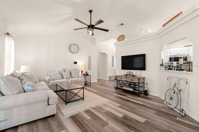 3292 NE 42nd Pl, Ocala, FL 34479 - living room featuring arched walkways, a ceiling fan, wood finished floors, and lofted ceiling