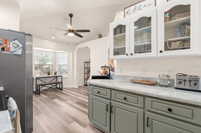 3292 NE 42nd Pl, Ocala, FL 34479 - kitchen featuring ceiling fan, white cabinetry, freestanding refrigerator, and arched walkways