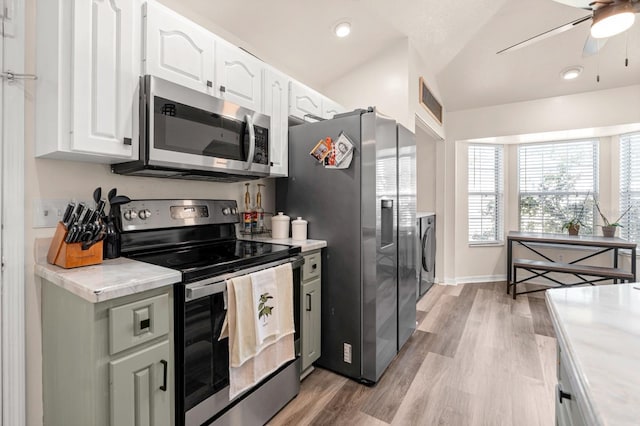 3292 NE 42nd Pl, Ocala, FL 34479 - kitchen with stainless steel appliances, white cabinetry, light countertops, washer / clothes dryer, and recessed lighting